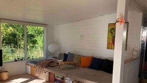 A cozy room with a built-in bench, bookshelves, a large window, and a wall-mounted lamp. - 4 Star Holiday Home in Nykobing Sj (Nykobing Sjaelland)