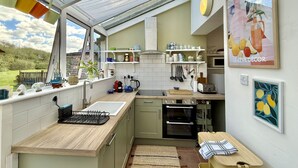 Una cucina con una finestra, un lavello, un fornello e un forno a microonde.