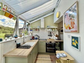 A kitchen with a window, a sink, a stove, and a microwave. - Cottage 493 - Clifden - sleeps 5 guests  in 3 bedrooms (Clifden)