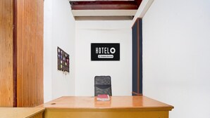 A hotel reception desk with a sign reading 'HOTELO Company Serviced.'