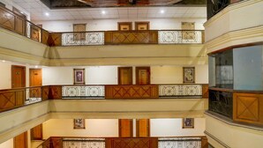 A multi-level interior with wooden railings and doors on each floor. - Deluxe Room Subhash Nagar Royal Palazzo (Jaipur)
