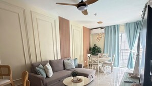 A modern living room with a sofa, a coffee table, a dining area with chairs, a ceiling fan, and a view through the window. - Apartment in Bávaro Punta Cana | Swimming Pool | Near the Beach (Punta Cana)