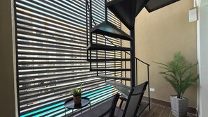 A balcony with a table, chairs, and a potted plant. - Apartment in Bávaro Punta Cana | Swimming Pool | Near the Beach (Punta Cana)