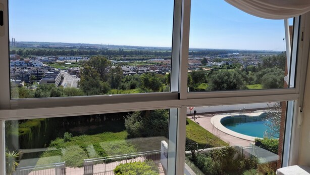 Ein Zimmer mit großen Fenstern und Blick auf eine Wohngegend sowie einen Swimmingpool.