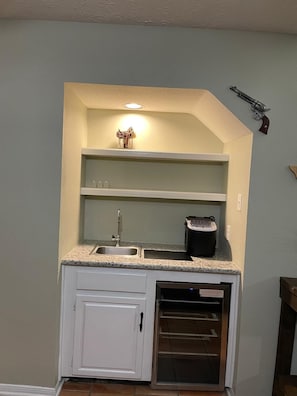 Una cocina compacta con horno integrado, un lavabo y una pequeña encimera.