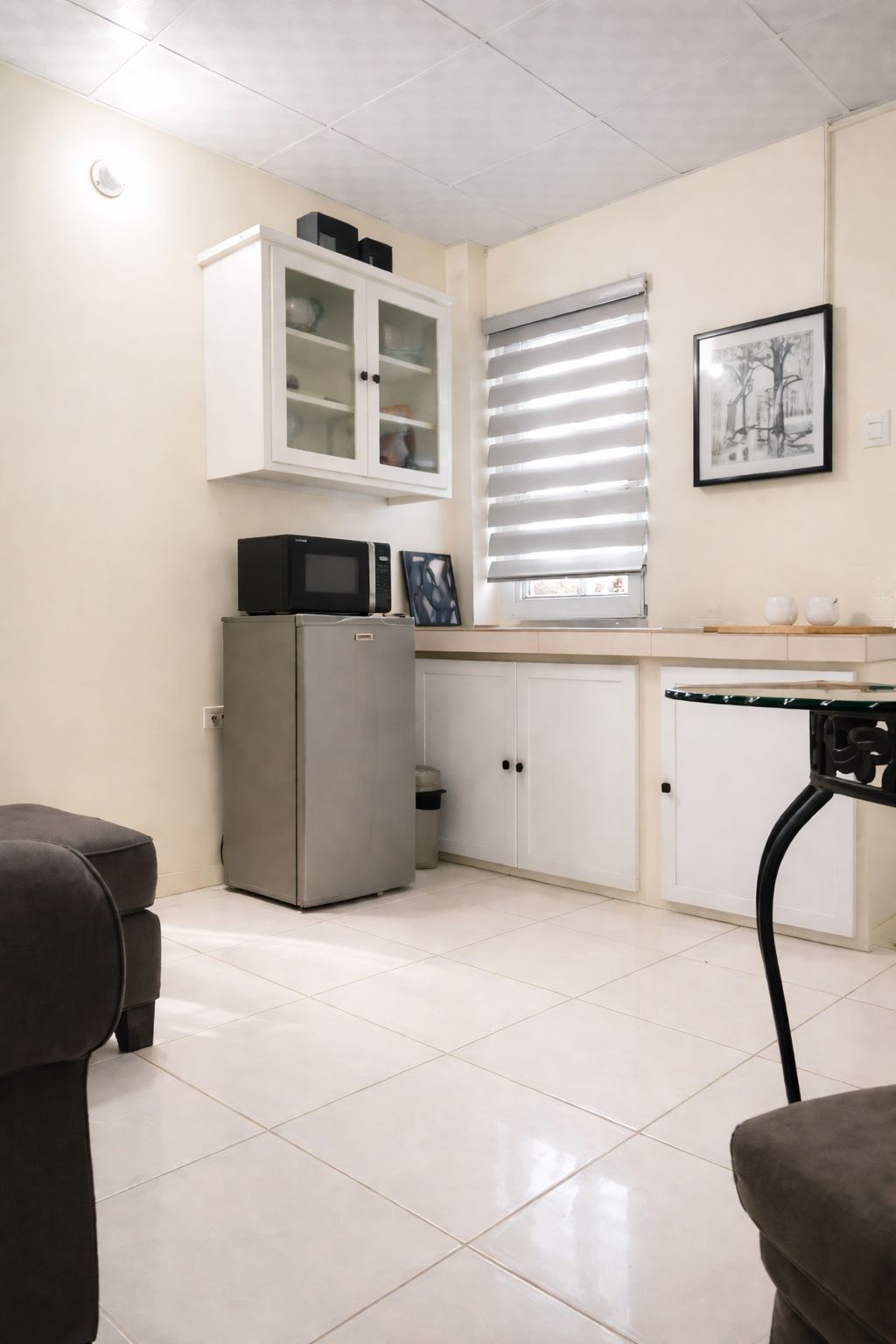 Una cocina compacta con refrigerador, microondas y armarios.