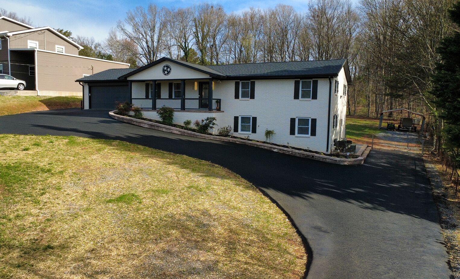 A two-story house with a garage, a driveway, and a lawn.