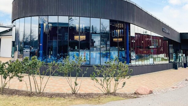 A modern building with a curved facade, large glass windows, and a sign reading 'GLASBÄREN.' - 6 Person Holiday Home in Kosta (Kosta)
