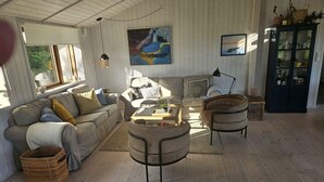 A cozy living room with a sofa, armchairs, a coffee table, and a cabinet. - 4 Star Holiday Home in Ebeltoft (Ebeltoft)