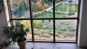 A large window with a view of a forested area and a house in the distance. - 4 Star Holiday Home in Ebeltoft (Ebeltoft)