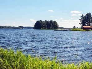 A lake with a small island and a red building on the shore. - 5 Star Holiday Home in Solleron (Sollerön)