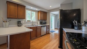A modern kitchen with wooden cabinets, stainless steel appliances, and a large island.