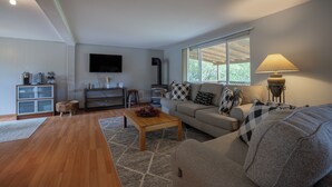 A modern living room with a sofa, coffee table, and a flat-screen TV.
