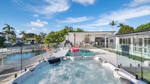 A rooftop pool with hot tubs, a dining area, and a view of the surrounding neighborhood. - Coastal Waterfront Broadbeach Waters (Broadbeach Waters)