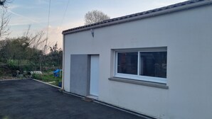 Un bâtiment à l’extérieur blanc, doté d’une fenêtre et d’une porte.