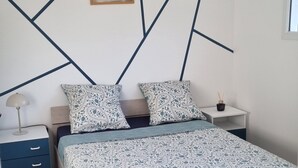 Une chambre à coucher avec un lit, des tables de chevet, une lampe, un tableau au mur et une fenêtre.