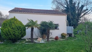 Un bâtiment d’un seul étage, doté d’un toit en tuiles, entouré d  ’un jardin bien entretenu, agrémenté de palmiers et de diverses espèces d’arbustes.