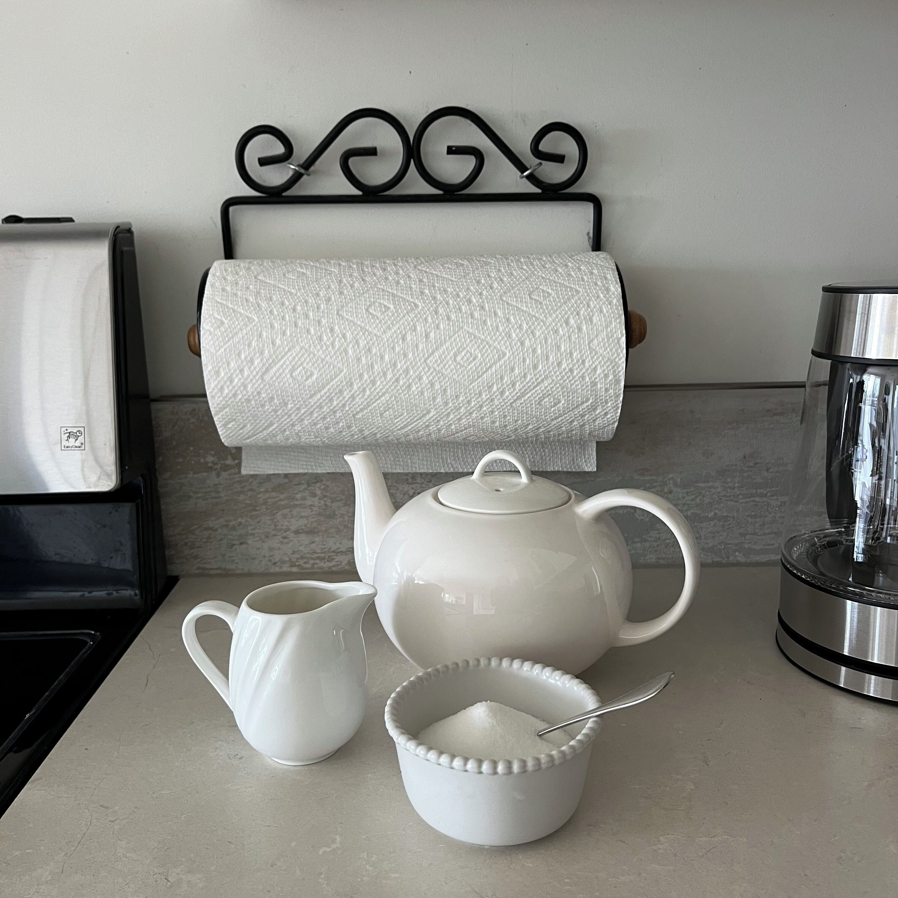 Une cuisine équipée d’un service à thé, d’une bouilloire, d’une machine à café et d’un porte-essuie-tout.