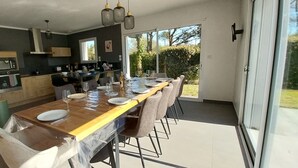 Uma cozinha moderna com área de refeições, janelas amplas e vista para o exterior.