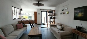 Un salon avec deux canapés, une table basse, un téléviseur et un baby-foot.