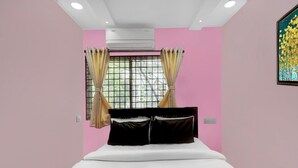 Quarto com cama, ar condicionado, janela com cortinas e um quadro na parede.