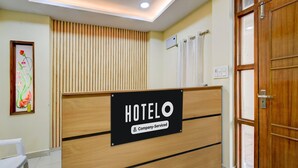 Uma receção com um letreiro a indicar 'HOTELO Company-Serviced'.