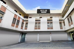 A hotel with a sign reading 'HOTEL' and 'Company Serviced,' featuring a modern architectural style with large windows and a flat roof. - Deluxe Hotel Birla Stay Inn (Hyderabad)