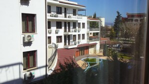Un edificio a più piani con balconi, condizionatori e una piscina.