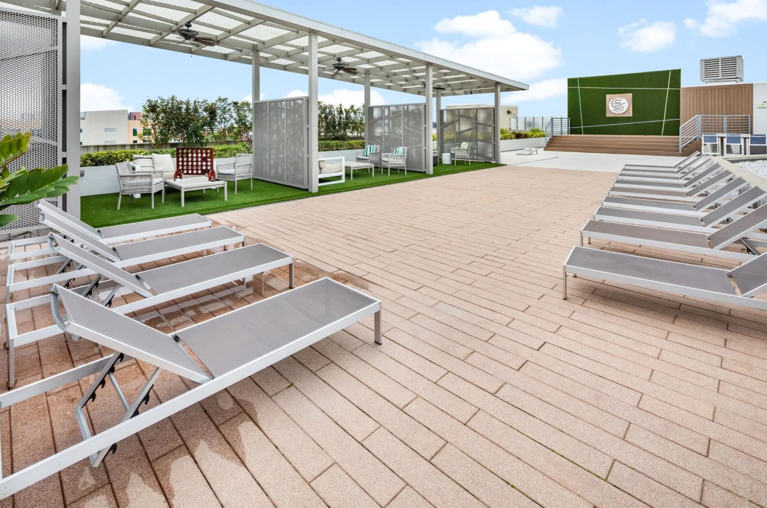 A rooftop patio with outdoor seating, a pergola, and a green wall.