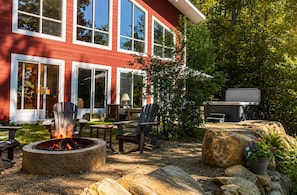 A red house with a fire pit, outdoor seating, and a grill area. - La Maison Magique- Private Hot Tub & Lake Access! (Sainte-Béatrix)