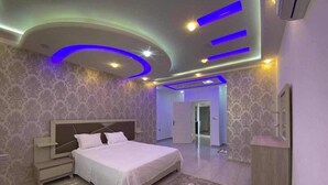 A bedroom with a bed, nightstands, a dresser, and a mirror. - Villa Laguna (Médenine)
