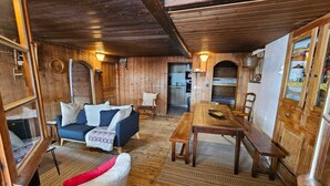Een rustiek houten interieur met een bank, een eettafel en een stoel.