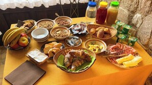 A table with various food items and condiments, including fruits, pastries, and beverages.