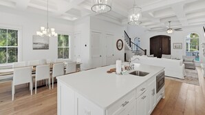 A spacious kitchen with a large island, white cabinetry, and pendant lighting. - Close to Beach, Gated Community, Sea-Esta Villa on 30A, Golf Cart Included (Santa Rosa Beach)