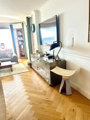 A living room with a herringbone floor, a sofa, a coffee table, a bookshelf, a TV, and a lamp. - Exceptional appartement with Sea view and beach private access (San Martino Di Lota)
