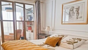 A bedroom with a bed, a nightstand, a lamp, a framed picture, and a sliding glass door leading to a balcony. - Exceptional appartement with Sea view and beach private access (San Martino Di Lota)