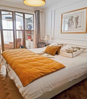 A bedroom with a bed, a nightstand, a lamp, a framed picture, and a sliding glass door leading to a balcony. - Exceptional appartement with Sea view and beach private access (San Martino Di Lota)
