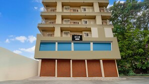 Un hôtel à plusieurs étages, doté de balcons, d’une enseigne indiquant qu’il s’agit d’un hôtel et d’une entrée de garage.