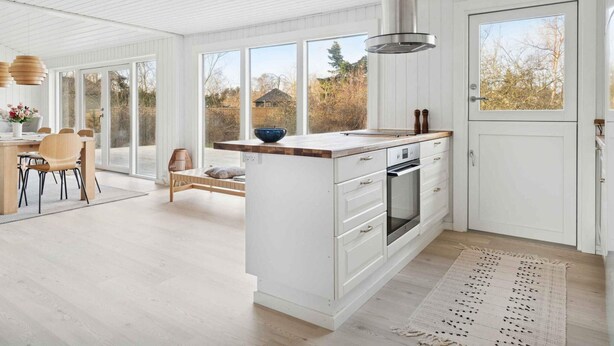 A modern kitchen with a central island, large windows, and a view of the outdoors. - 4 Star Holiday Home in Vaeggerlose (Vaeggerlose)