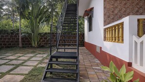 Una escalera que conduce a un edificio con un muro de ladrillo y fachada blanca y roja.
