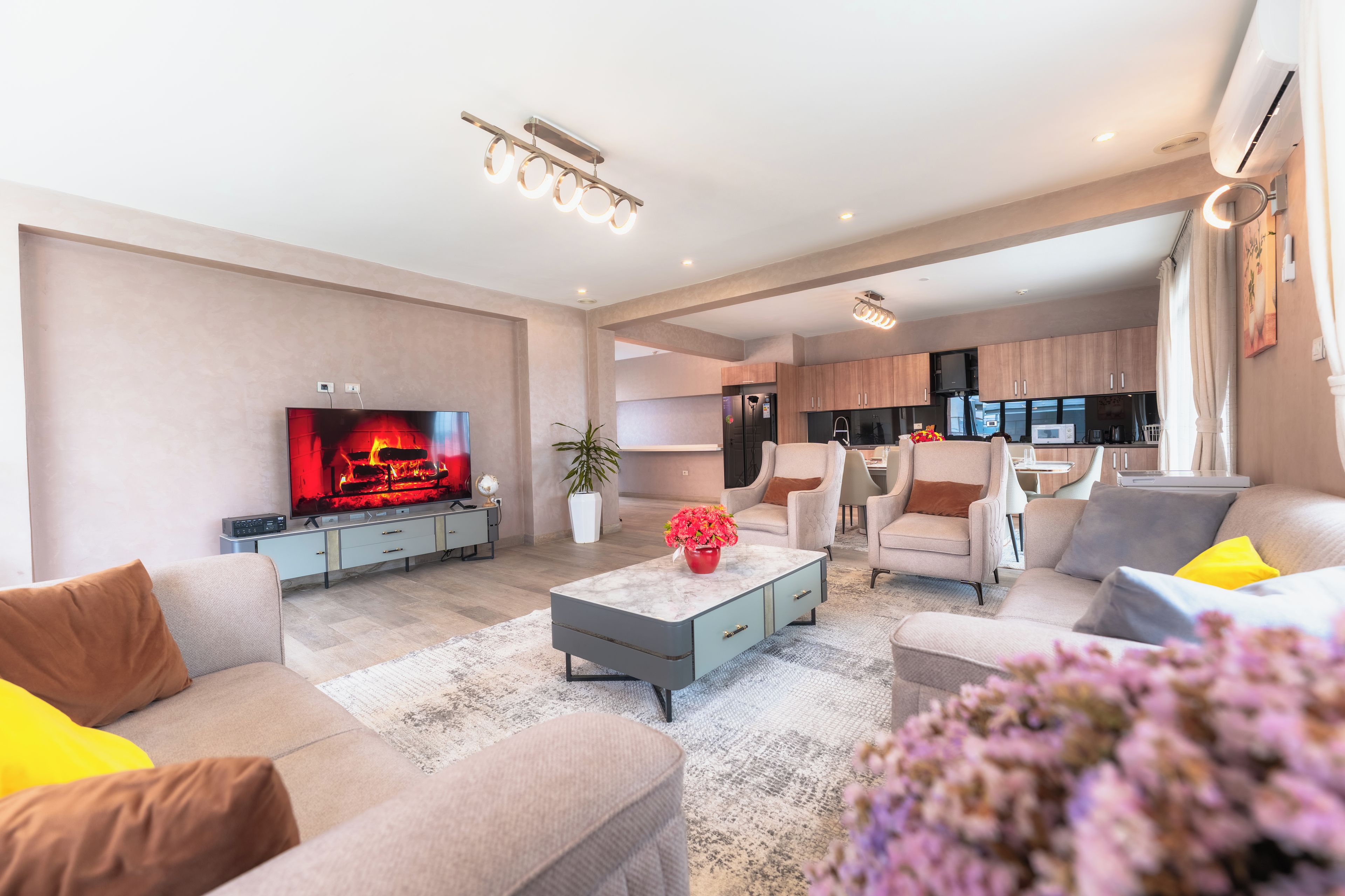 A modern living room with a flat-screen TV, a coffee table, and seating.
