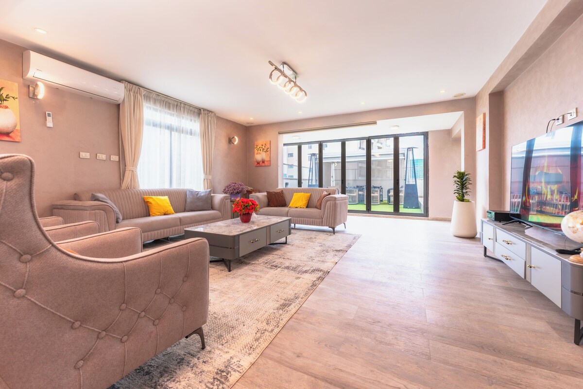 A modern living room with a sofa set, a coffee table, and a TV.