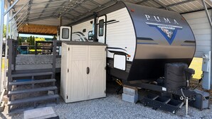 A PUMA RV with a covered outdoor area, a wooden deck, and a grill. - Wake&Lake at Norris Landing Marina-Waterfront RV Retreat with Deck + Slip Option (Tazewell)