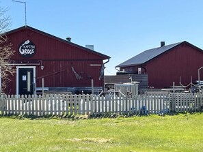 A red barn with a sign reading 'Kapten Krogg' and a white picket fence in front. - 4 Person Holiday Home in Hemse (Hemse)