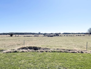 A flat landscape with a fence in the foreground and a building in the distance. - 4 Person Holiday Home in Hemse (Hemse)