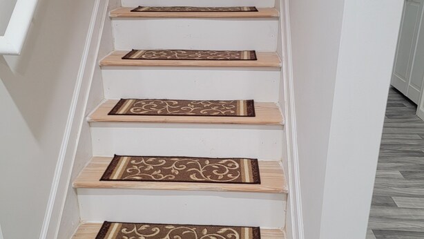 Una escalera con escalones de madera y diseños decorativos en los peldaños.