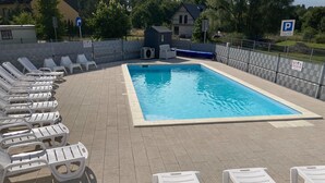 A swimming pool with lounge chairs arranged around it. - Two-story Holiday Homes With a Summer Pool (Postomino)