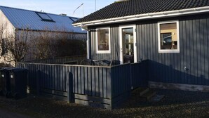 A small, single-story building with a dark exterior, a tiled roof, and a fenced outdoor area. - 4 Star Holiday Home in Borkop (Borkop)