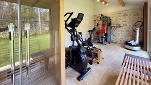 A gym with exercise equipment, a treadmill, and a stationary bike.