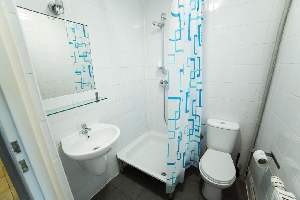 Un bagno con doccia, lavandino, WC e ripiano in vetro.